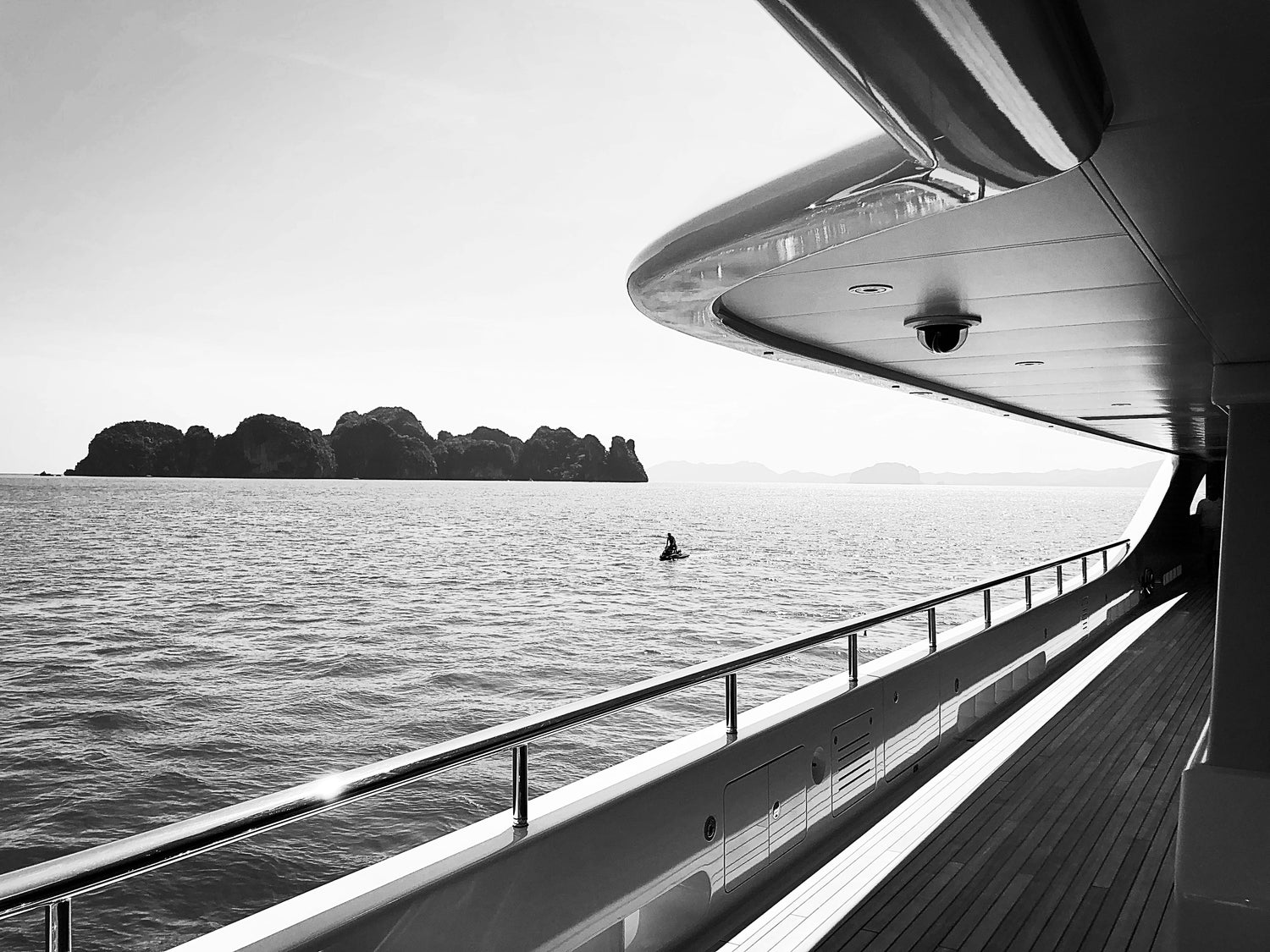 B+W view of an ocean island from the side of a yacht
